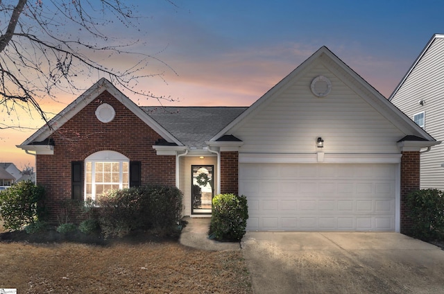 ranch-style home with a garage, concrete driveway, brick siding, and a shingled roof