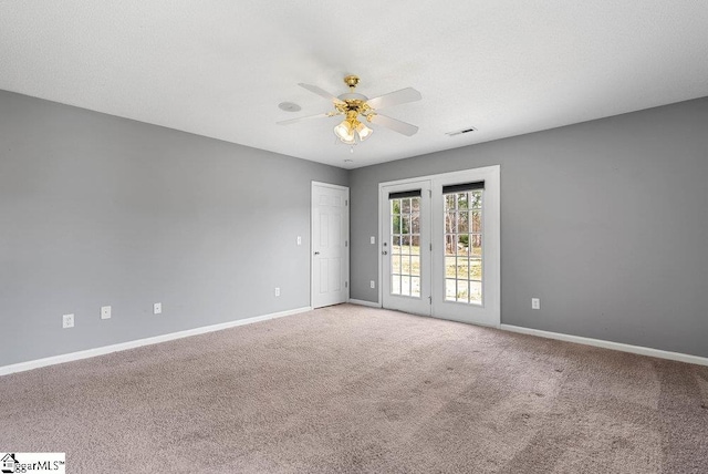 unfurnished room featuring baseboards, visible vents, a ceiling fan, and light colored carpet