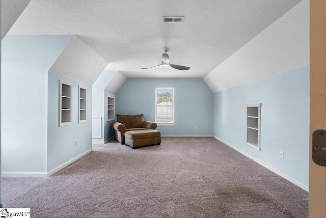 unfurnished room with a textured ceiling, baseboards, visible vents, and built in features