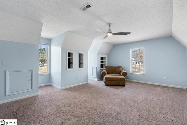 unfurnished room featuring carpet floors, a healthy amount of sunlight, visible vents, and a textured ceiling