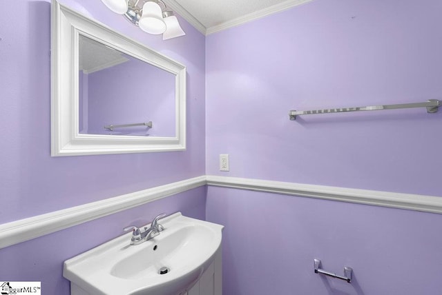 bathroom featuring ornamental molding and vanity