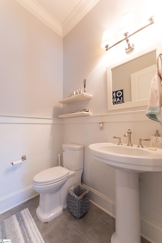 bathroom featuring ornamental molding, a sink, toilet, and baseboards