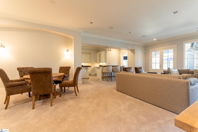 living room with ornamental molding, recessed lighting, french doors, and light carpet