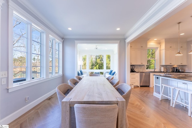 dining area with recessed lighting, a healthy amount of sunlight, crown molding, and baseboards