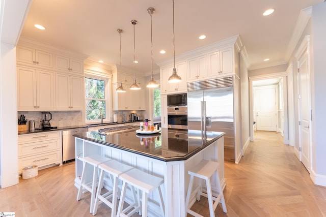 kitchen with built in appliances, a breakfast bar, backsplash, dark countertops, and crown molding