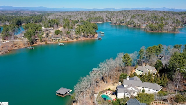 aerial view with a water and mountain view and a view of trees