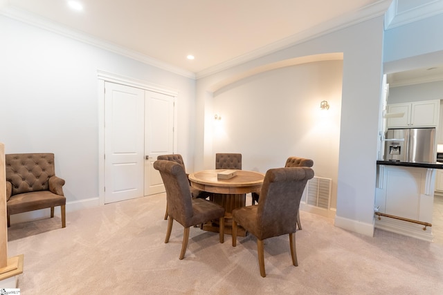 dining space with light carpet, baseboards, visible vents, and crown molding