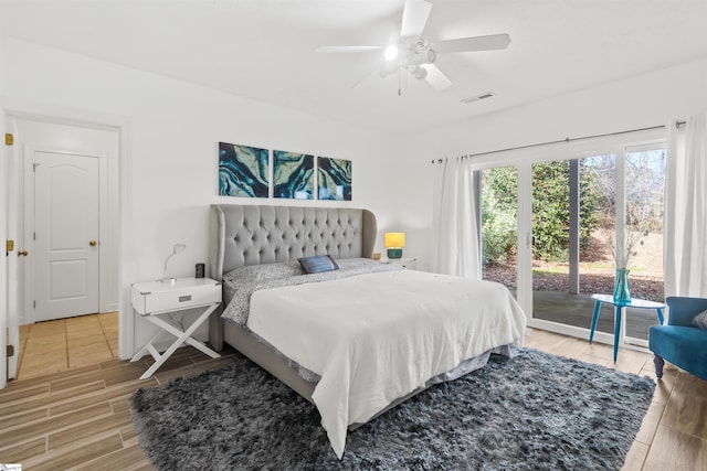 bedroom featuring access to exterior, visible vents, a ceiling fan, wood tiled floor, and baseboards