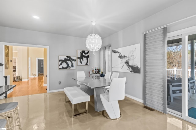 dining space with finished concrete flooring, visible vents, and baseboards