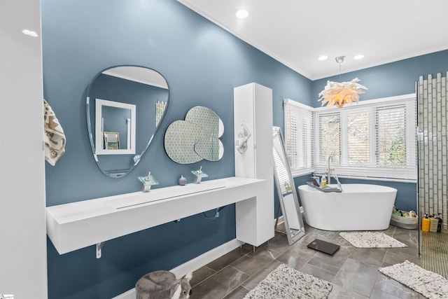 bathroom featuring a freestanding tub, baseboards, and recessed lighting