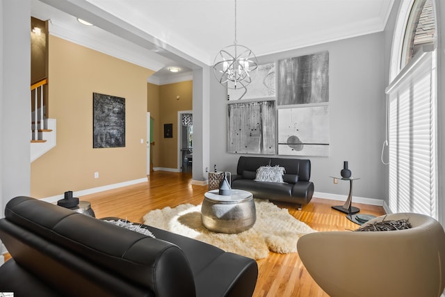 living area with baseboards, stairway, ornamental molding, wood finished floors, and a chandelier