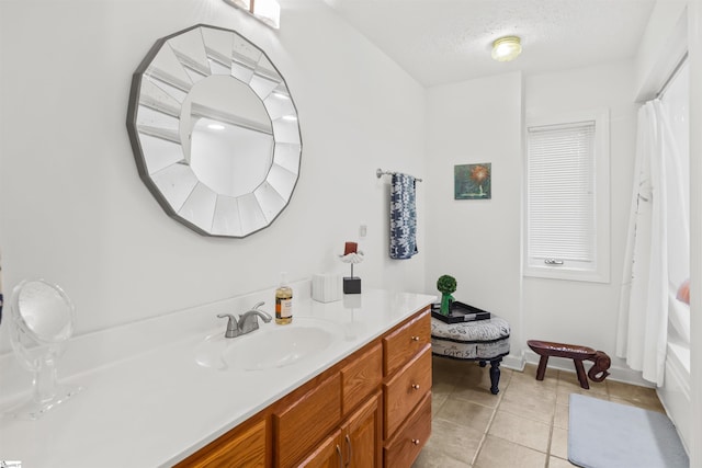 bathroom featuring a textured ceiling, tile patterned flooring, and vanity