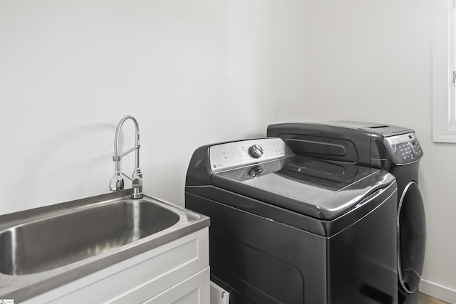 laundry room featuring a sink, cabinet space, and washer and dryer