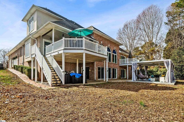 rear view of property featuring a patio area, brick siding, and stairway