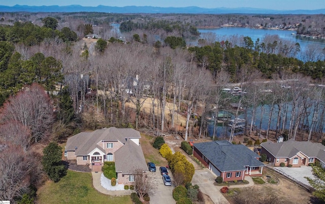 birds eye view of property with a water view and a view of trees