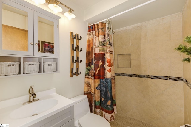 bathroom featuring tiled shower, vanity, and toilet