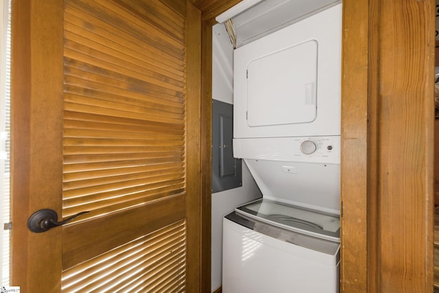 clothes washing area with laundry area, stacked washer and clothes dryer, and electric panel