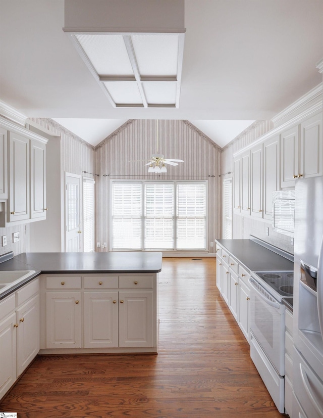 kitchen featuring lofted ceiling, electric range, fridge with ice dispenser, and white cabinets