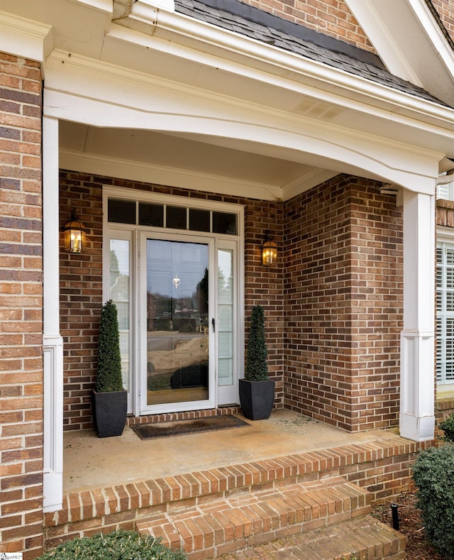 view of exterior entry featuring brick siding