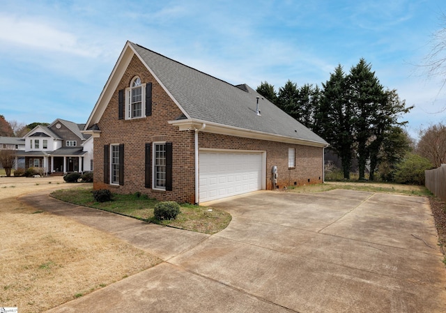 view of side of property with a shingled roof, fence, concrete driveway, and brick siding