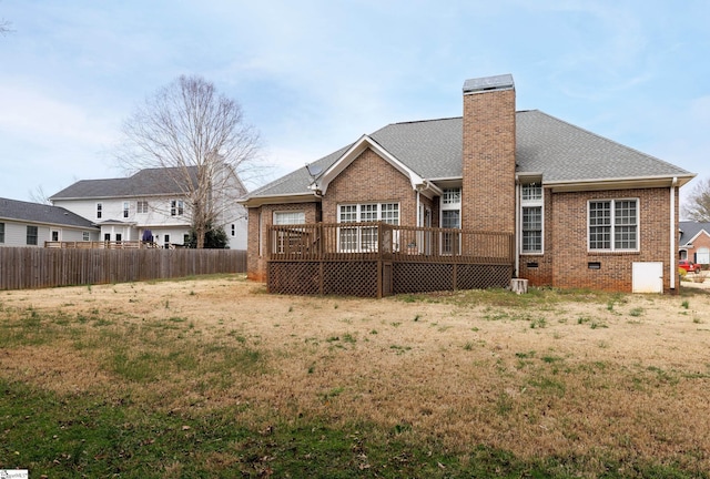 back of house with brick siding, fence, roof with shingles, a wooden deck, and a chimney