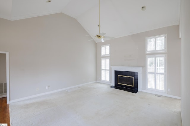 unfurnished living room with high vaulted ceiling, a tile fireplace, and plenty of natural light