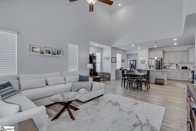 living room with recessed lighting, ceiling fan, and light wood finished floors