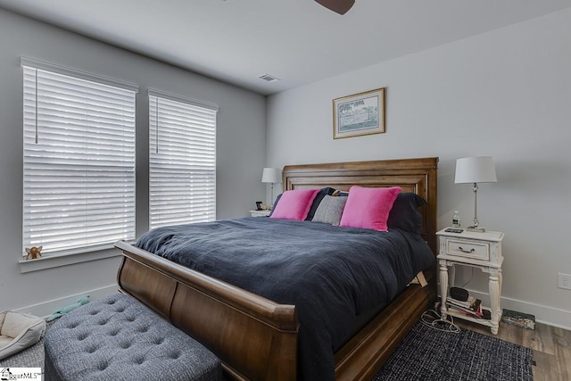 bedroom with visible vents, ceiling fan, baseboards, and wood finished floors