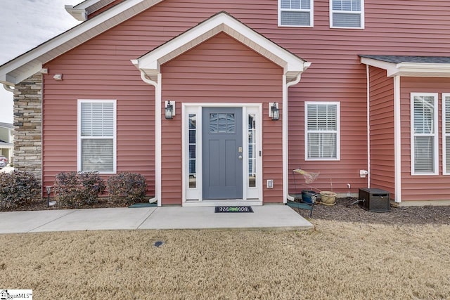 property entrance with a yard and central air condition unit