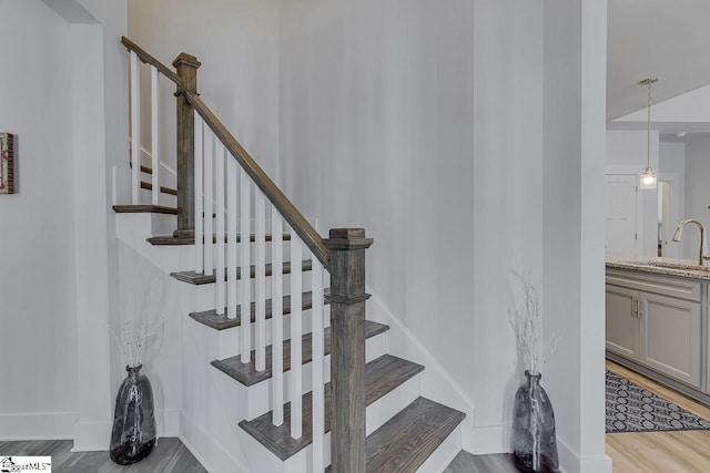 staircase with baseboards and wood finished floors