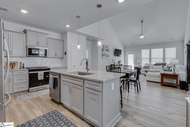 kitchen with visible vents, appliances with stainless steel finishes, a sink, and gray cabinetry