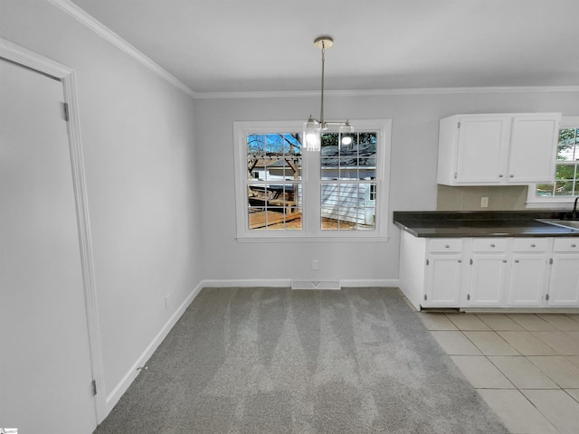 unfurnished dining area featuring baseboards, visible vents, a sink, light carpet, and crown molding