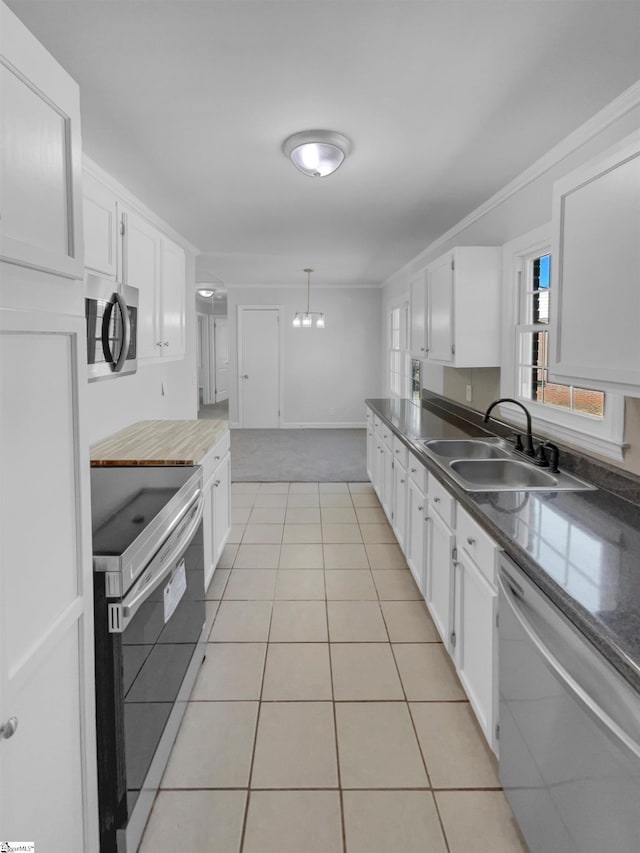 kitchen featuring a sink, white cabinets, light tile patterned flooring, and stainless steel appliances