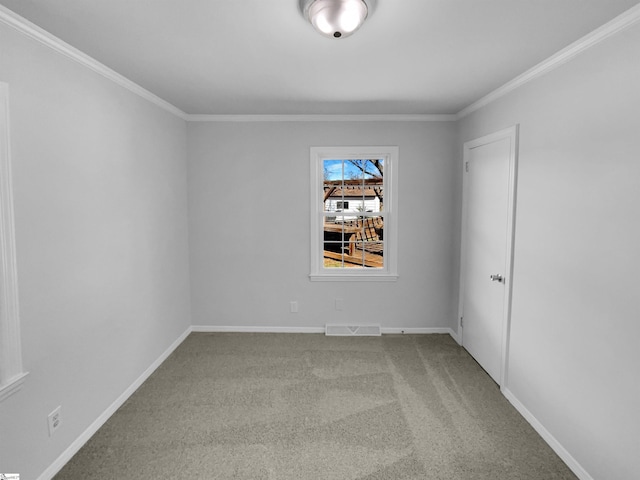 spare room featuring visible vents, baseboards, ornamental molding, and carpet flooring