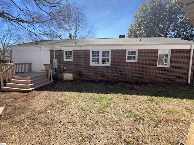 rear view of house with crawl space, a deck, a lawn, and brick siding