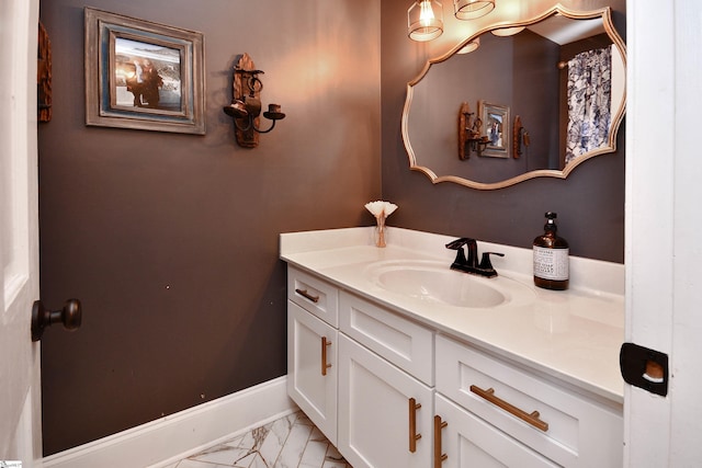 bathroom with marble finish floor, baseboards, and vanity