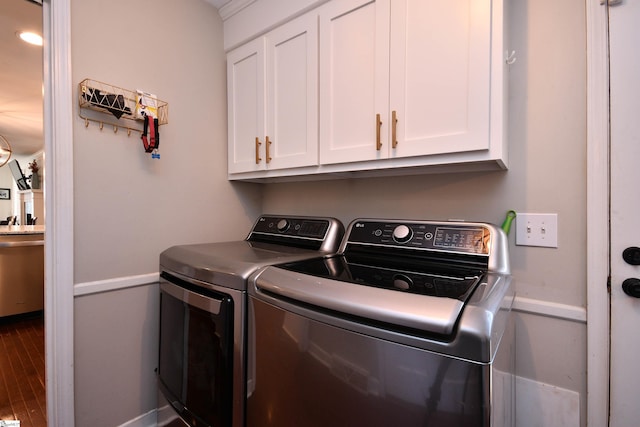 clothes washing area featuring cabinet space, separate washer and dryer, and wood finished floors