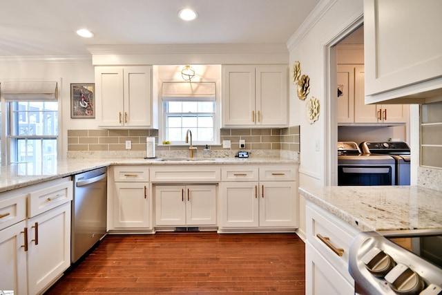 kitchen featuring separate washer and dryer, a sink, white cabinetry, stainless steel dishwasher, and crown molding