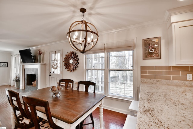 dining room with baseboards, a fireplace, dark wood finished floors, and crown molding