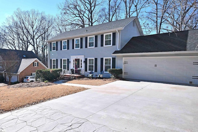 colonial inspired home featuring a garage and concrete driveway