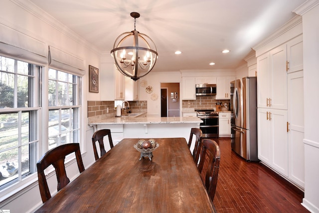 dining area featuring crown molding, dark wood-style flooring, a notable chandelier, and recessed lighting