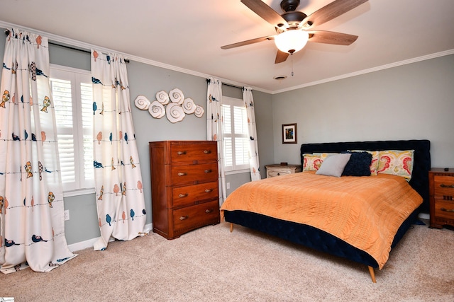 carpeted bedroom featuring ornamental molding, ceiling fan, and baseboards