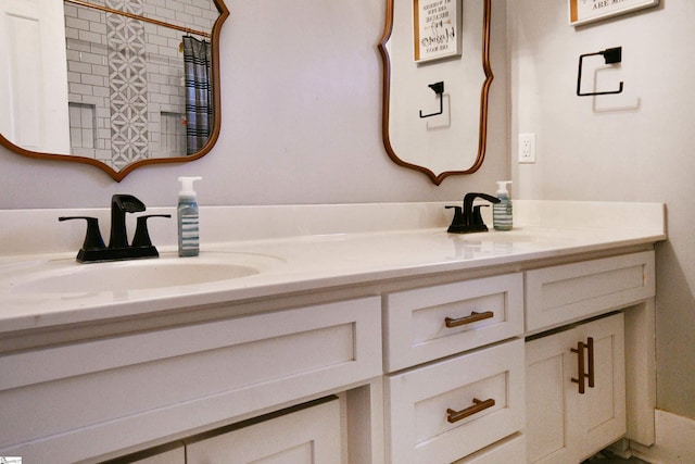 bathroom featuring double vanity, curtained shower, and a sink