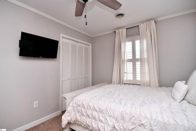 carpeted bedroom featuring baseboards, visible vents, a ceiling fan, crown molding, and a closet