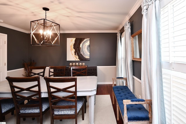 dining area with a healthy amount of sunlight, an inviting chandelier, crown molding, and wood finished floors