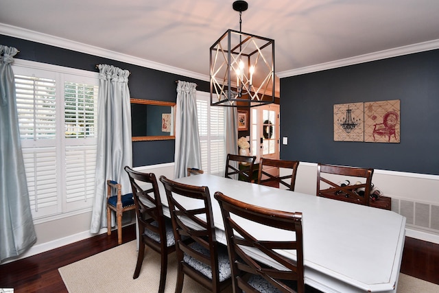 dining area with baseboards, crown molding, an inviting chandelier, and wood finished floors