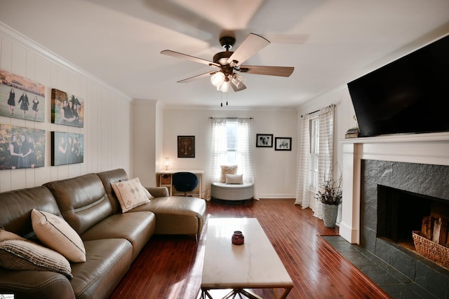 living room with baseboards, dark wood-style floors, ceiling fan, a premium fireplace, and crown molding