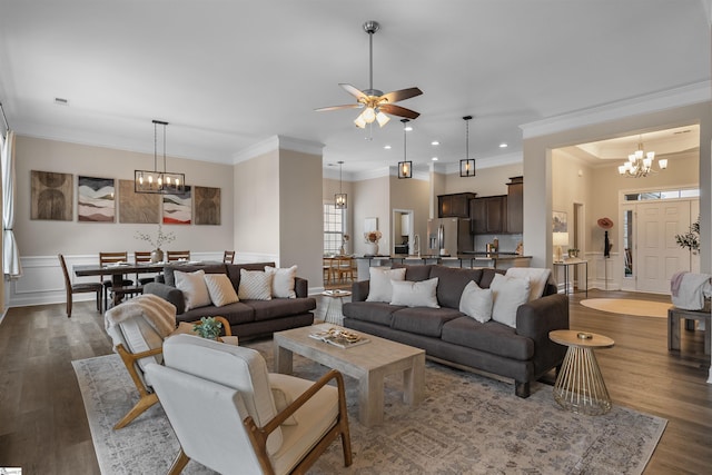 living area with recessed lighting, ornamental molding, dark wood-style flooring, and ceiling fan with notable chandelier