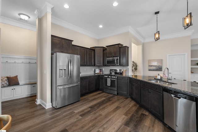 kitchen featuring dark stone countertops, dark wood finished floors, a sink, stainless steel appliances, and dark brown cabinets