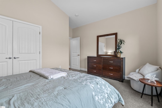 carpeted bedroom with a closet and vaulted ceiling